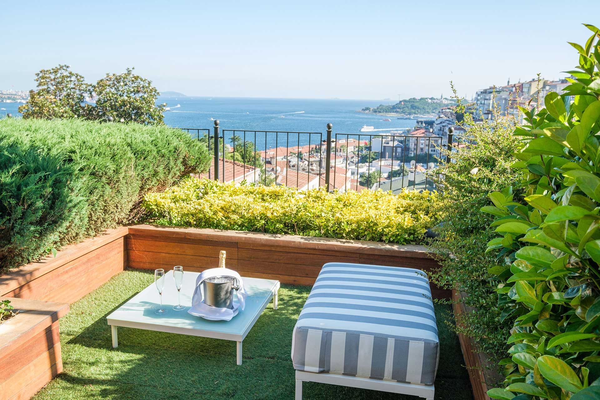 Cozy patio with a striped bench, champagne bucket & glasses at CVK Park Prestige Suites Istanbul