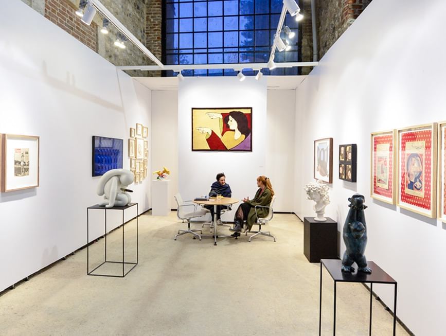 Two people engaging in a discussion at an art fair near CVK Hotels