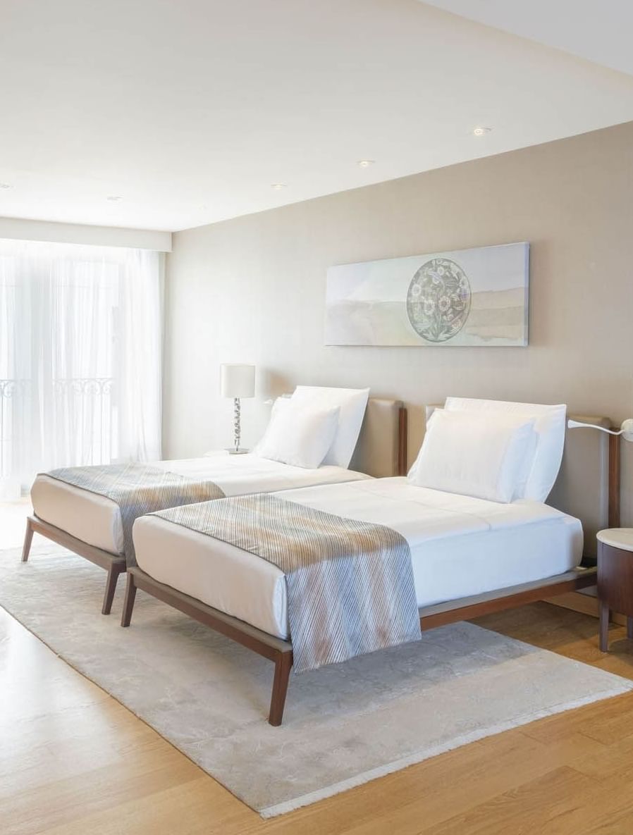 Two twin beds and a television in a room with wooden floors at CVK Hotels