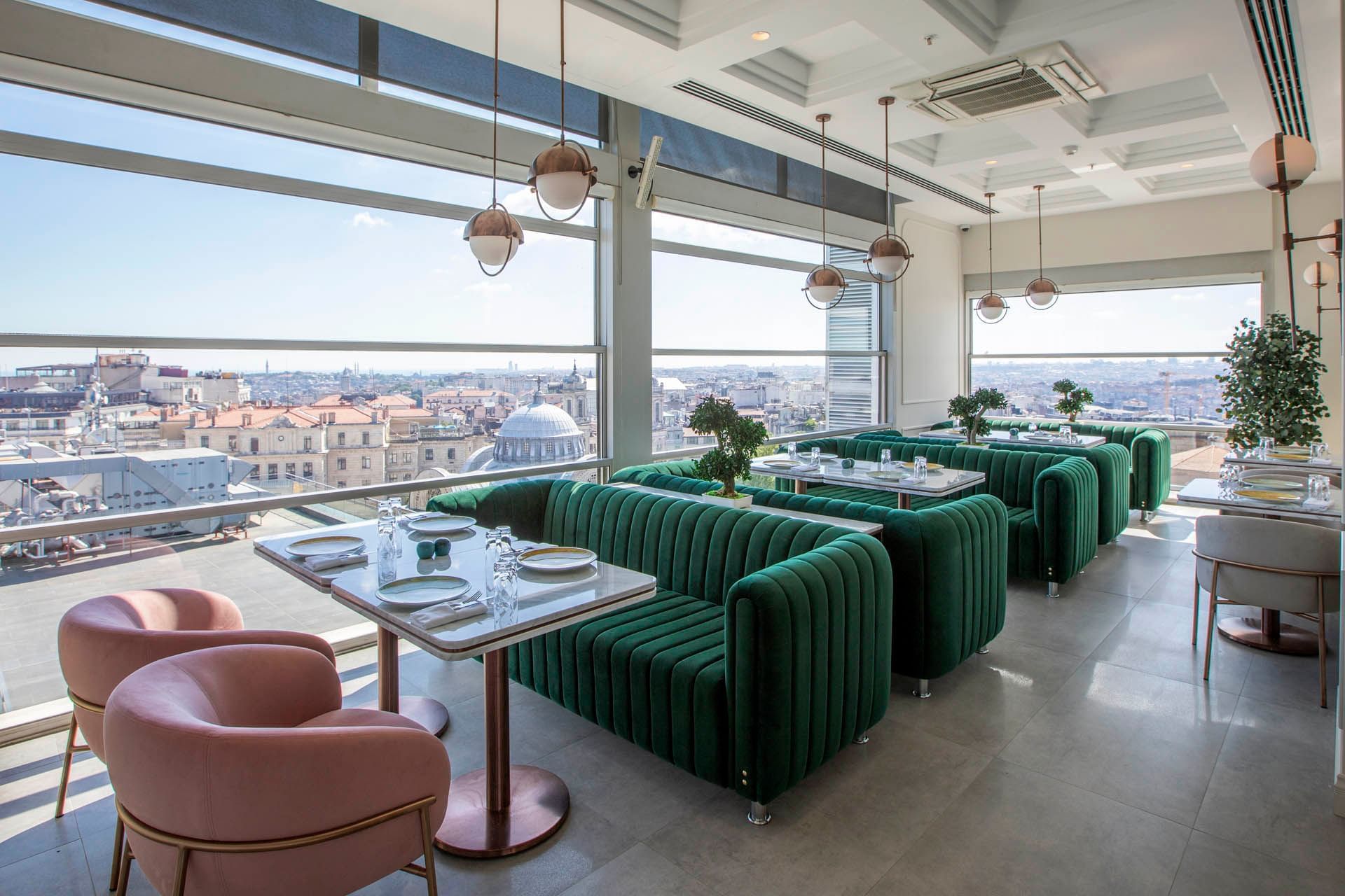 Dining area with plush seating & city view in Ashiya Restaurant & Terrace Bar at CVK Taksim Hotel Istanbul
