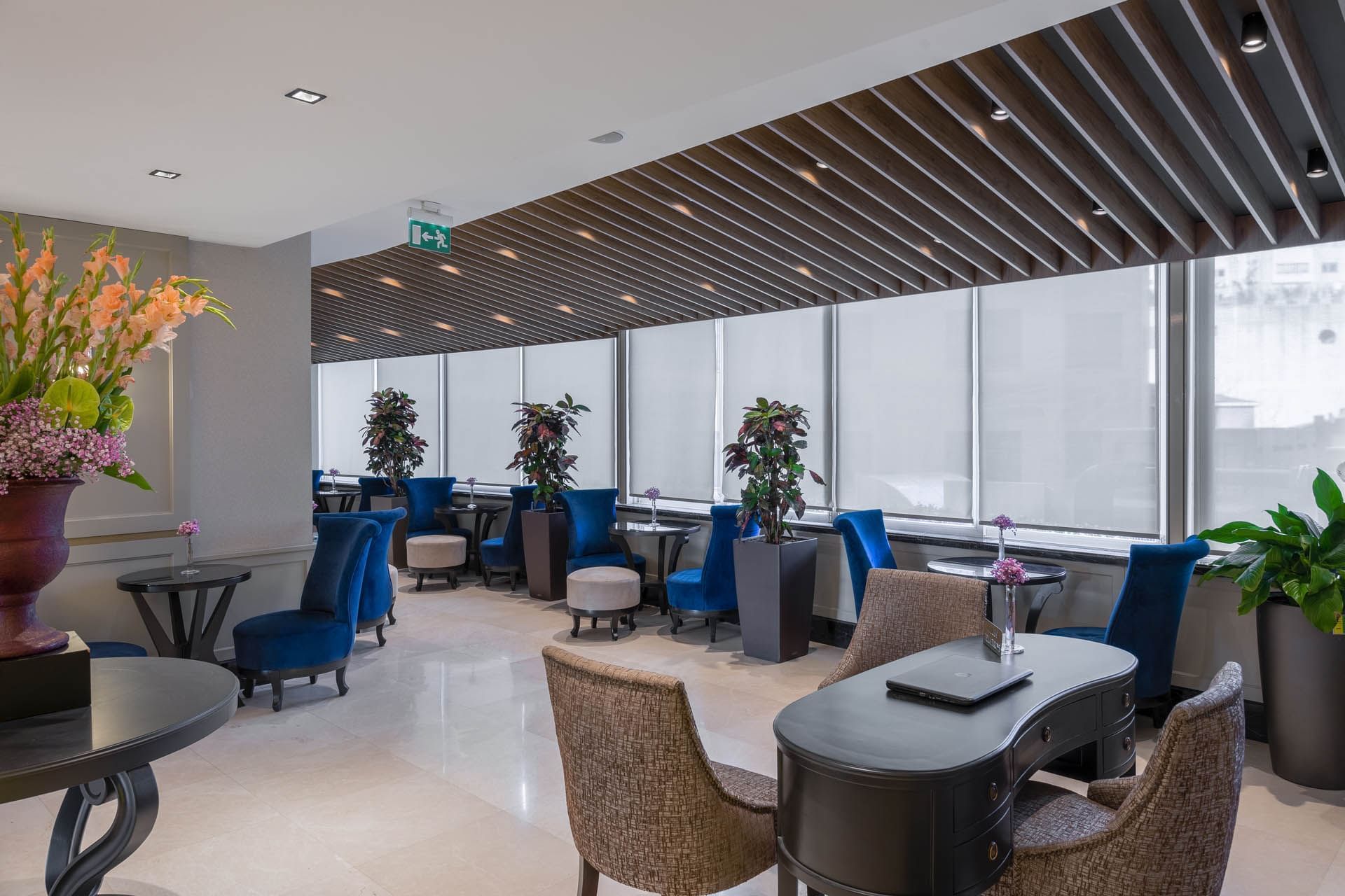 Lobby lounge area with cozy chairs, potted plants, and large windows at CVK Taksim Hotel Istanbul