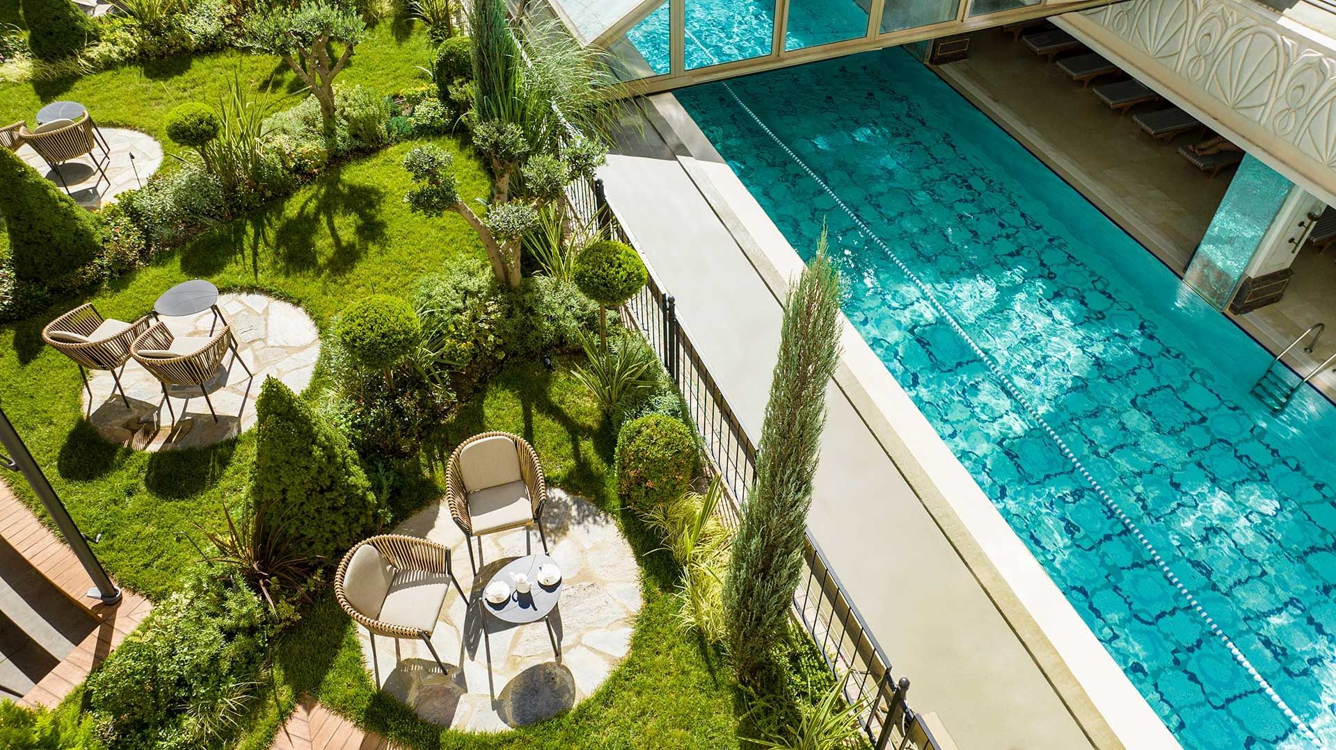 Aerial view of Studio Garden Terrace with garden, shrubs, lounge chairs, and pool at CVK Park Prestige Suites Istanbul