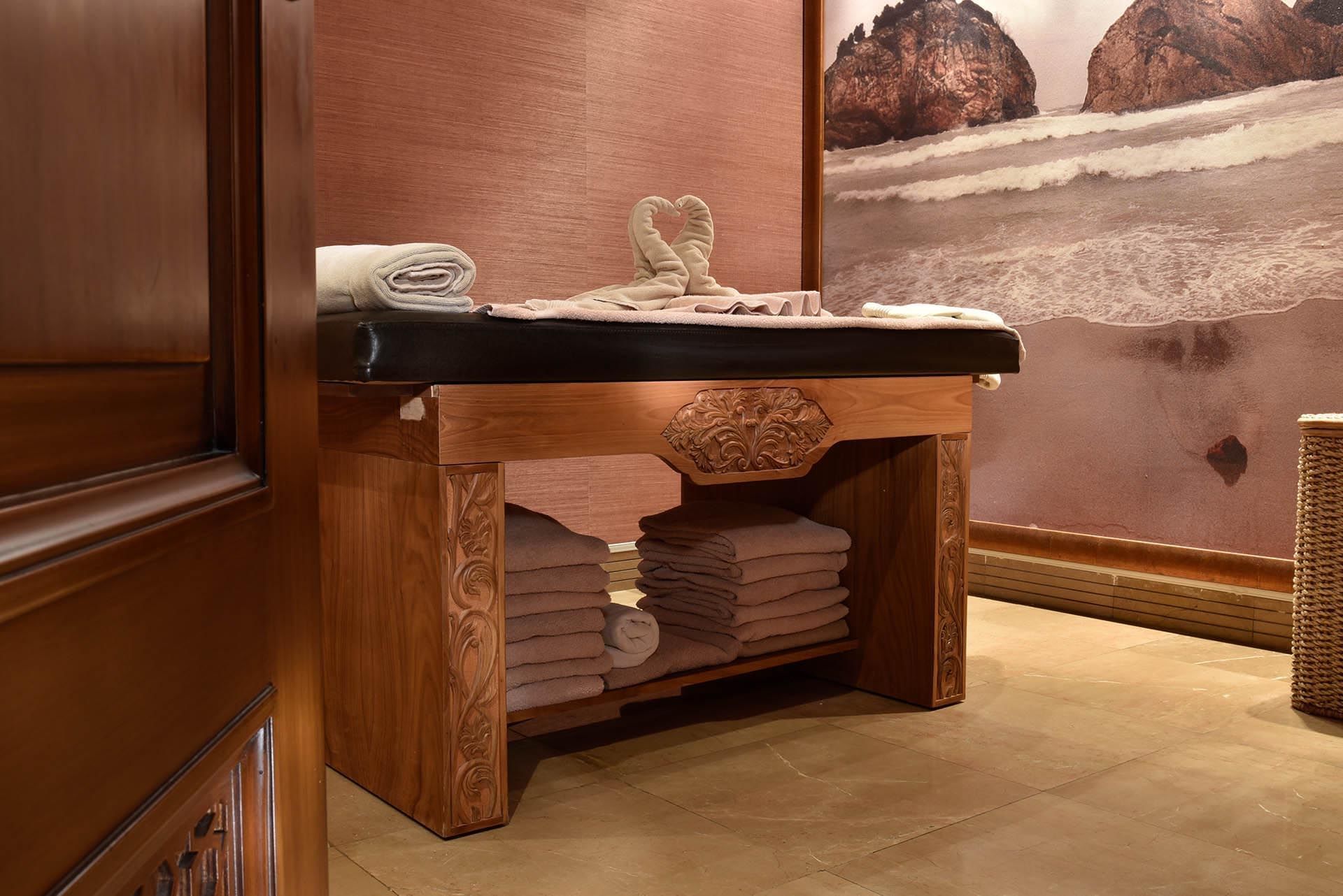Wooden massage table with heart-shaped towel swans in Angkor Wat Spa at CVK Taksim Hotel Istanbul