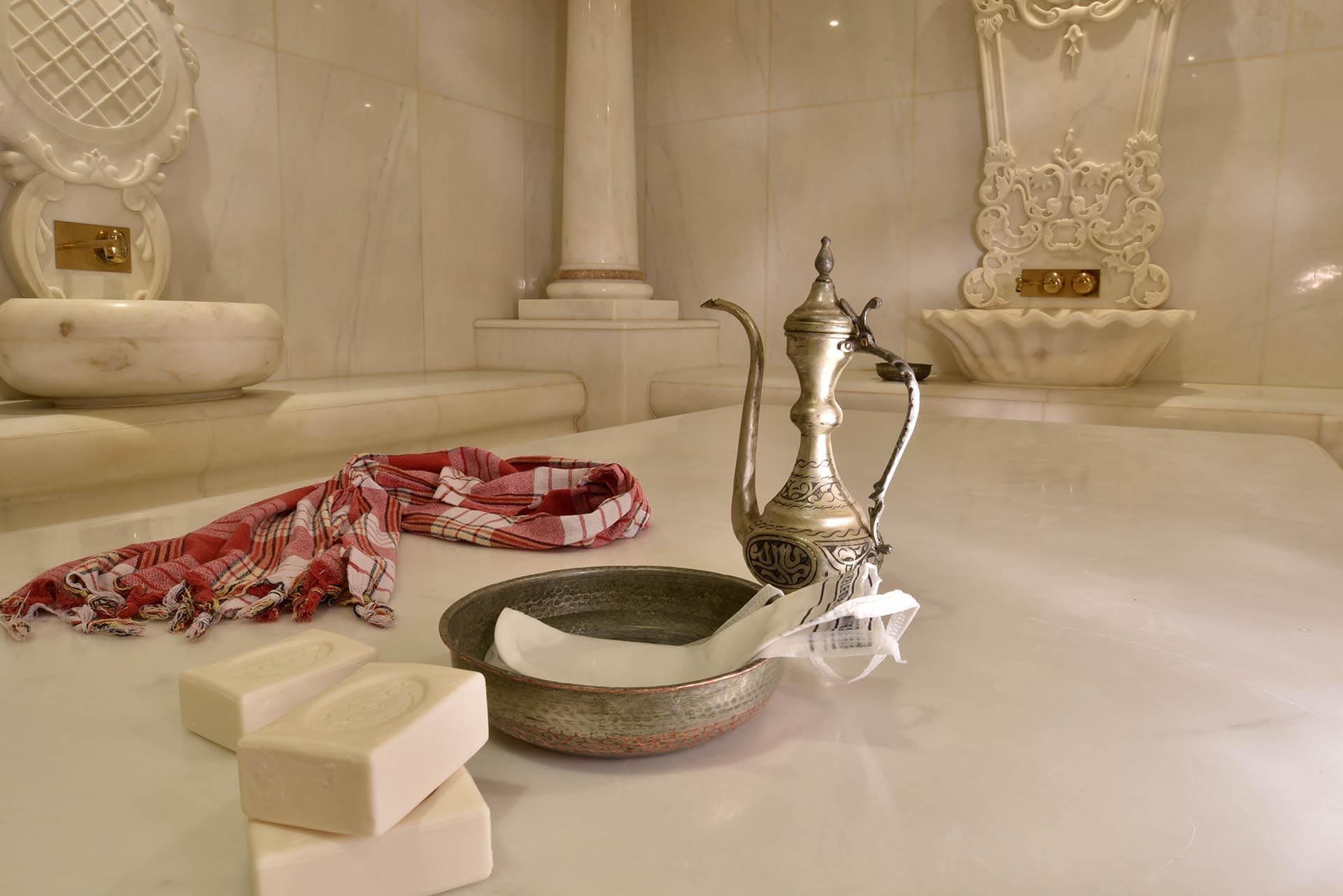 Marble hammam with ornate wall fountains and a central heated stone platform in Angkor Wat Spa at CVK Taksim Hotel Istanbul