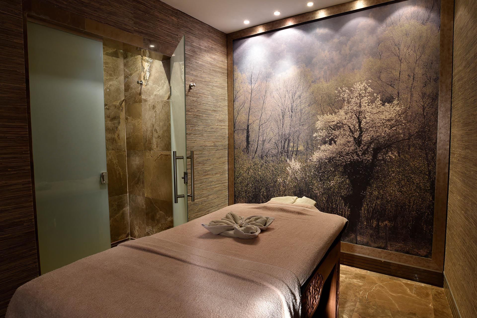 Massage table and a nature-themed mural in Angkor Wat Spa at CVK Taksim Hotel Istanbul